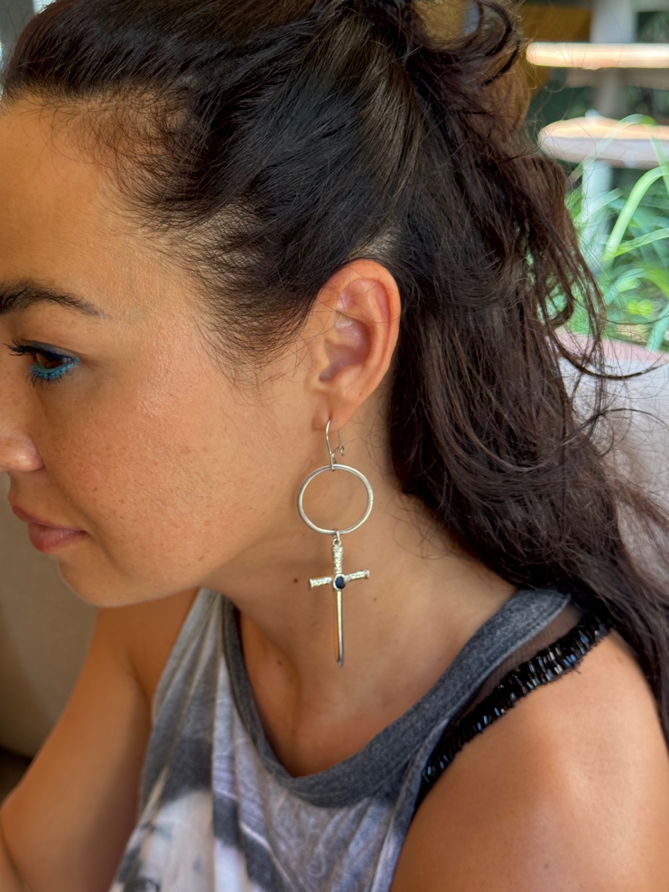 The Sapphire Cross worn as a single sculptural earring