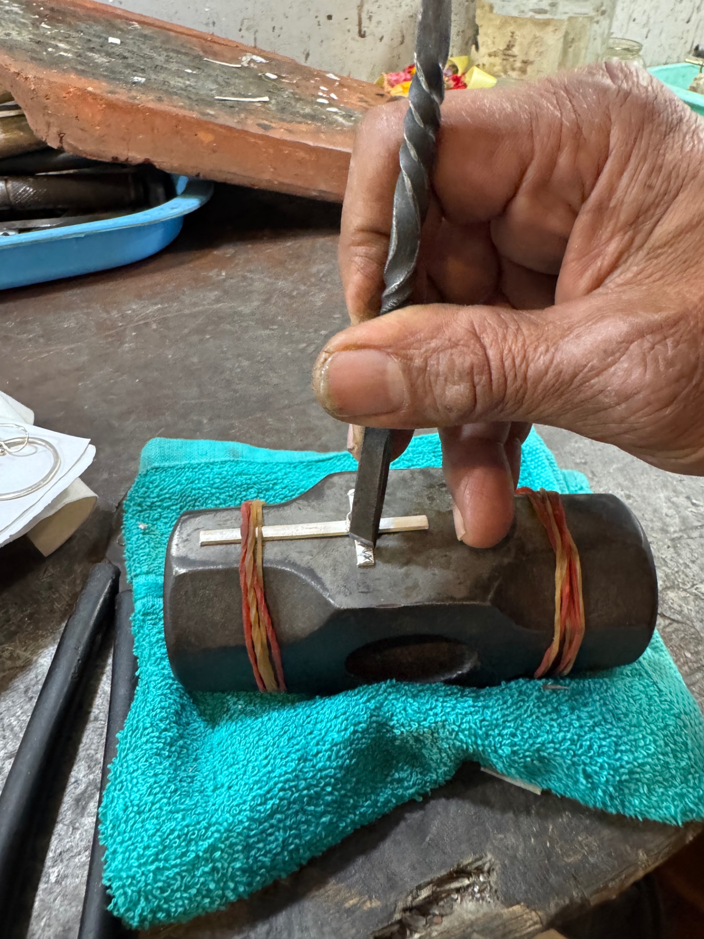 Hand engraving the silver with a punch tool on an anvil