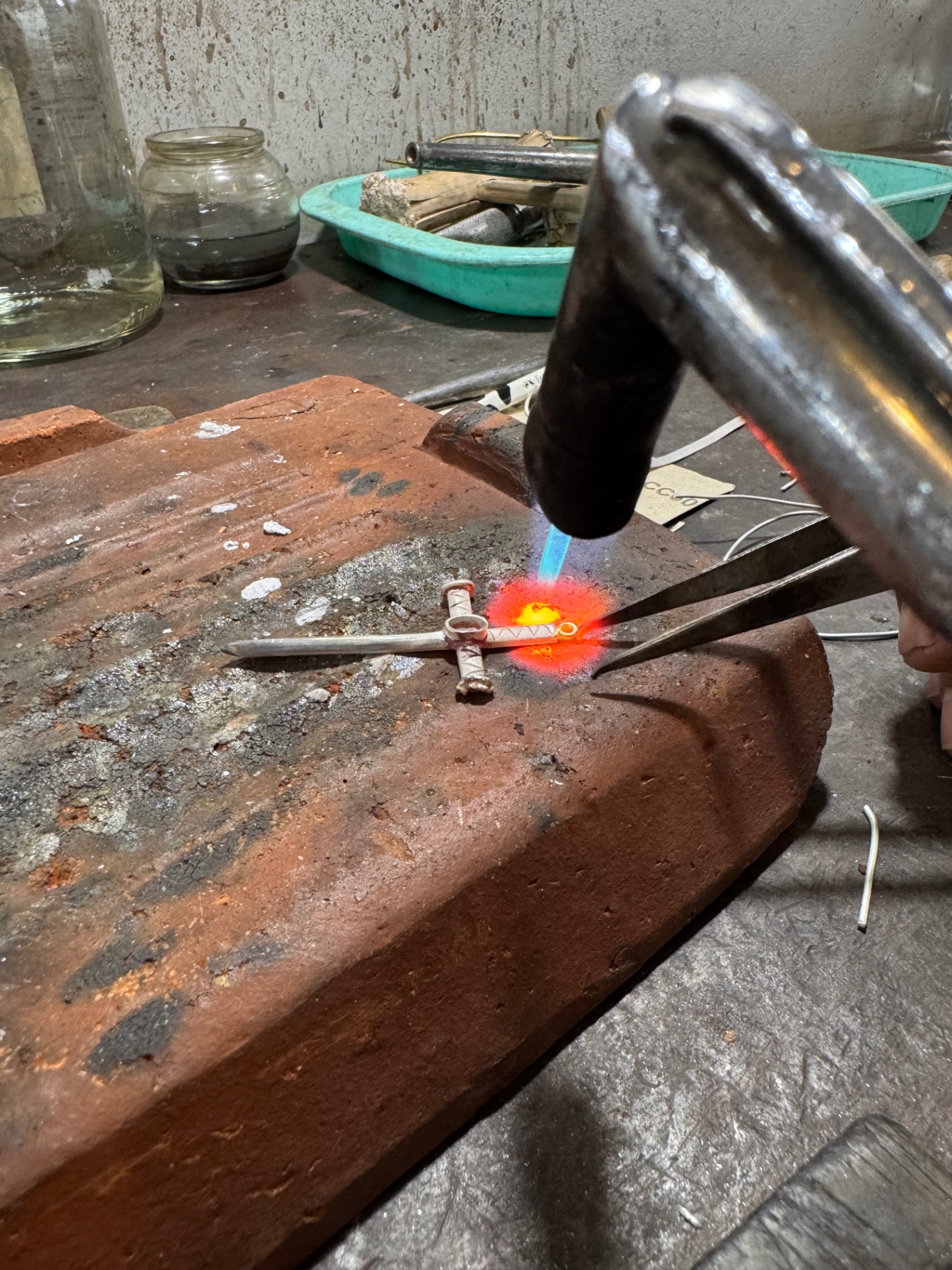 Glowing silver being soldered with a torch